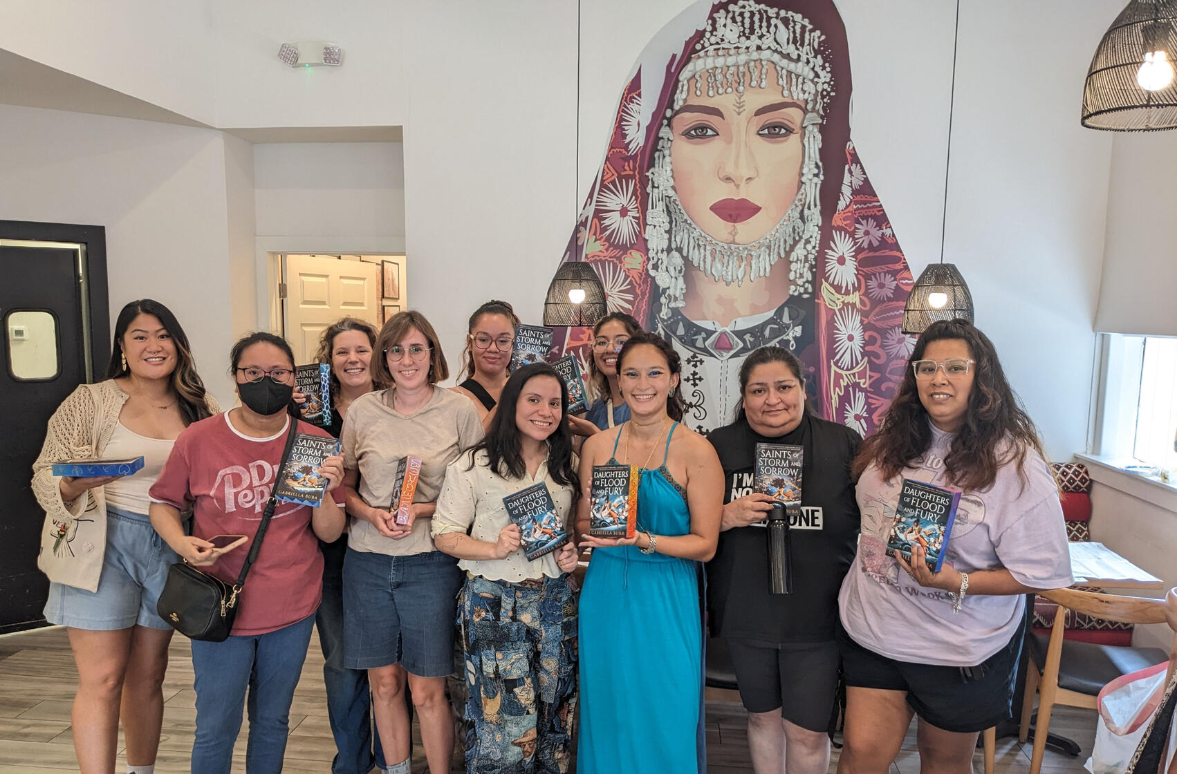 Images of 3 custom edge painted copies of Saints of Storm and Sorrow with bi flag colors, lesbian flag colors, and the rainbow flag