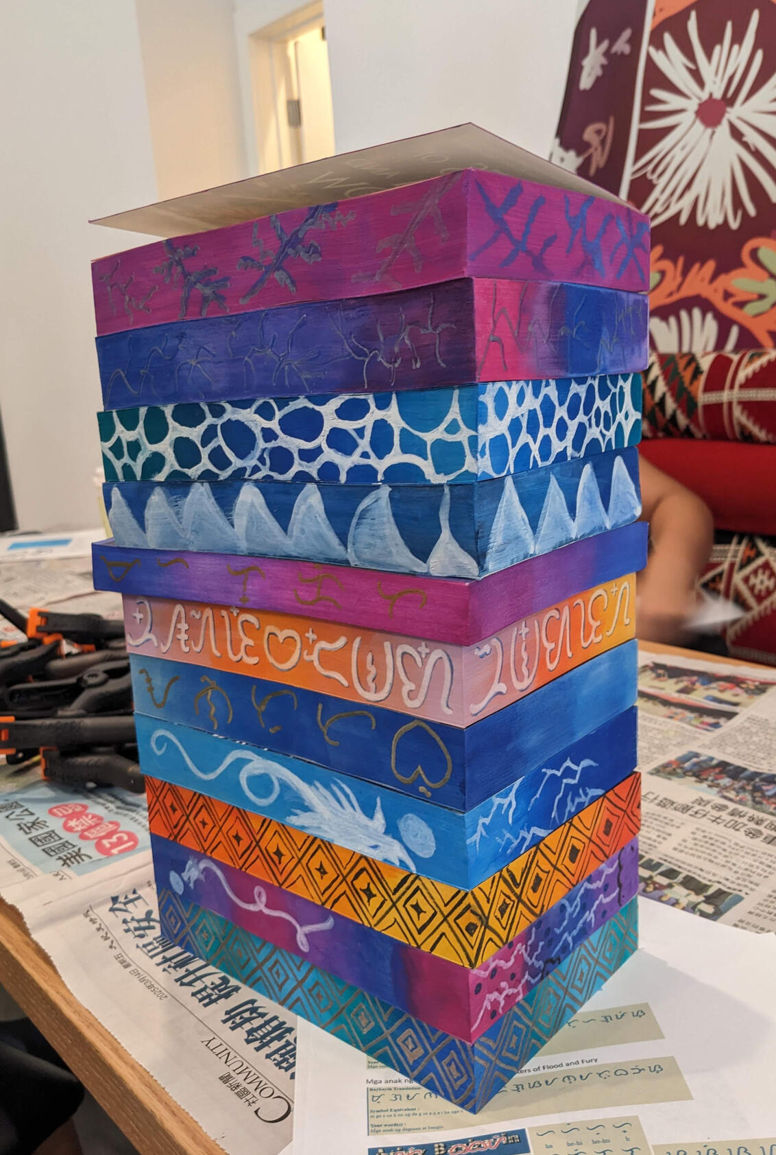 Images of 3 custom edge painted copies of Saints of Storm and Sorrow with bi flag colors, lesbian flag colors, and the rainbow flag